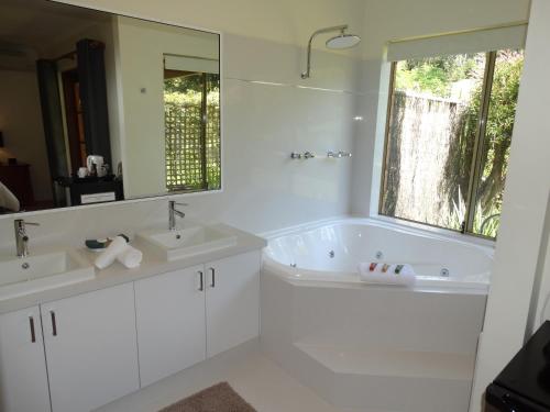 a white bathroom with two sinks and a large mirror at Pinda Lodge in Margaret River Town