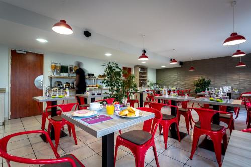 un restaurant avec des chaises rouges et des tables avec de la nourriture dans l'établissement Adams Hotel, à Metz