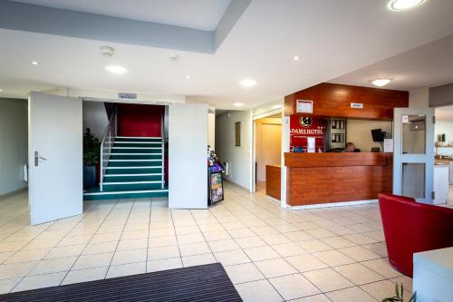 a lobby of a fast food restaurant with a staircase at Adams Hotel in Metz