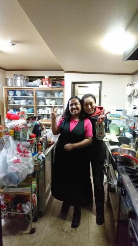 two women posing for a picture in a kitchen at Live Cafe Hisui no Umi in Itoigawa