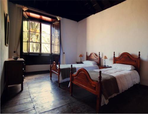 a bedroom with two twin beds and a window at Casa Rural El Palmar in Vallehermoso