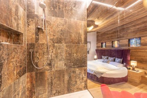 a bathroom with a shower and a bed in a room at Alpine Residence Villa Adler in San Vigilio Di Marebbe