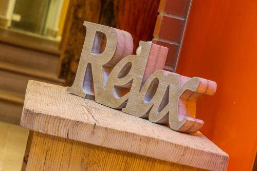 a wooden sign that says rave sitting on a ledge at Alpine Residence Villa Adler in San Vigilio Di Marebbe