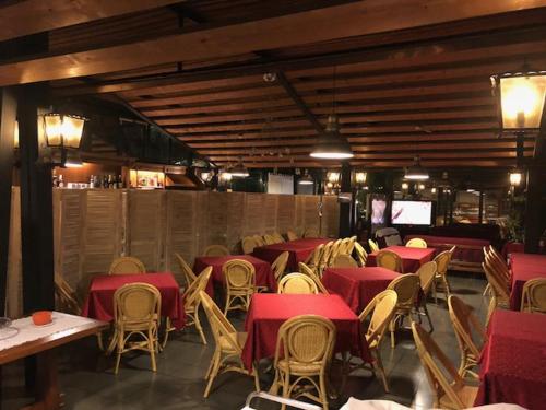 a dining room with tables and chairs and red tables at Hotel Il Granaio in Porto Mantovano