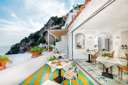 a balcony with tables and chairs and a view of the ocean at Casa Guadagno in Positano