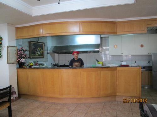 a person standing behind a counter in a kitchen at Huangjia Motel in Tainan