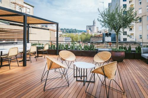 a patio area with chairs, tables and umbrellas at Hotel Ultonia in Girona