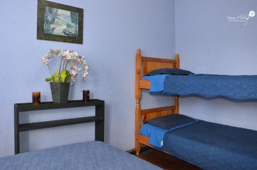 1 Schlafzimmer mit 2 Etagenbetten und einem Tisch mit Blumen in der Unterkunft Hostal Alua Rio in Quito