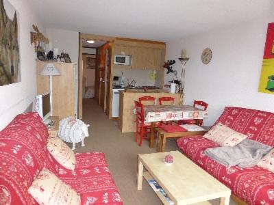 un salon avec deux canapés rouges et une cuisine dans l'établissement Ski Soleil 211, à Manigod