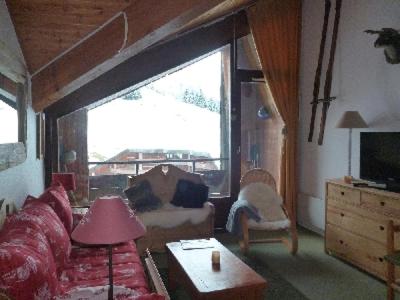 a living room with a couch and a large window at LES FEUDIERES in Manigod