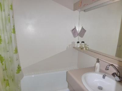 une salle de bain avec un lavabo, une baignoire et un miroir dans l'établissement Ski Soleil 211, à Manigod