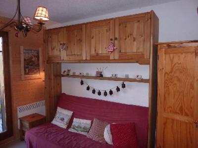 a bedroom with a red bed and wooden cabinets at MONT BLANC Soleil B-4 in Manigod