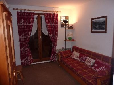 un salon avec un canapé et une fenêtre dans l'établissement MONT BLANC Soleil B-13, à Manigod