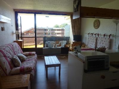 un salon avec un canapé et une cuisine dans l'établissement LES Herbelaines 133, à Manigod