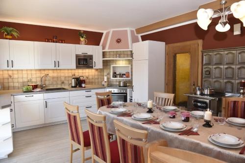 a kitchen with a large table with chairs and white cabinets at Haus Sonnenschein Mariapfarr in Mariapfarr