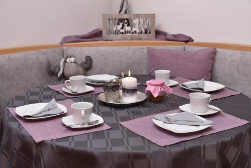 a table with plates and cups and candles on it at Haus Sonnenschein Mariapfarr in Mariapfarr