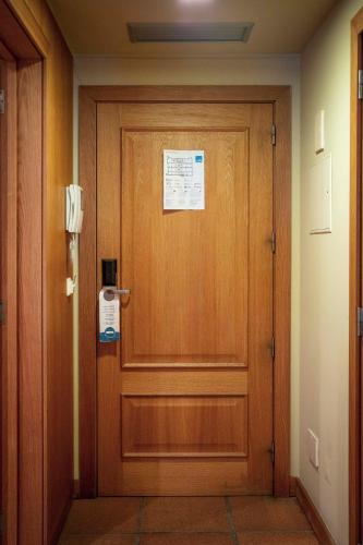 a wooden door in a hallway with a sign on it at Apartamentos Turisticos Atlantida in Funchal