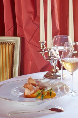 a plate of food on a table with wine glasses at Chateau d'Audrieu in Audrieu