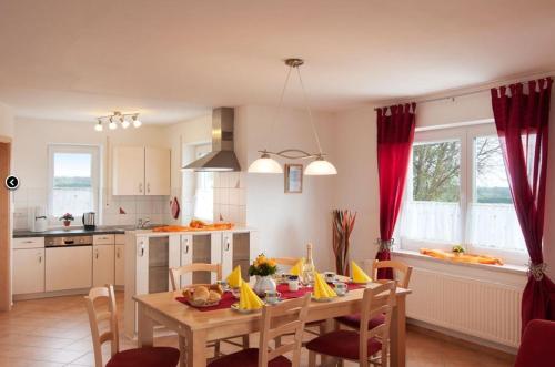 a kitchen with a wooden table and a dining room at Ferienhof Musch GbR in Rot an der Rot