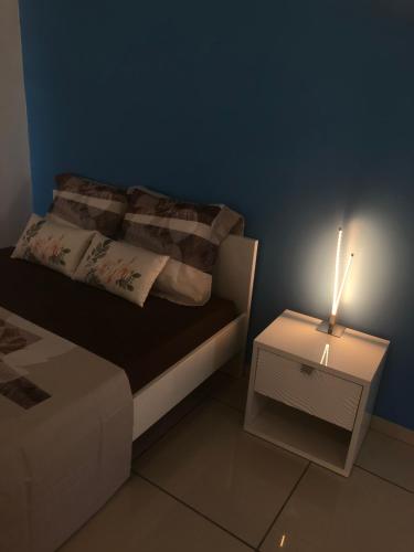 a small bedroom with a bed and a nightstand with a lamp at Appartement « Lilas » SEAVIEW in Le Marin