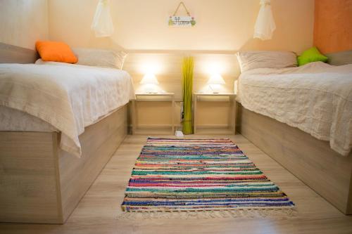 a bedroom with two beds and a rug on the floor at 4 Seasons apartments, A1 in Plovdiv