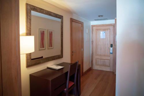 a room with a desk and a mirror and a door at Apartamentos Turisticos Atlantida in Funchal