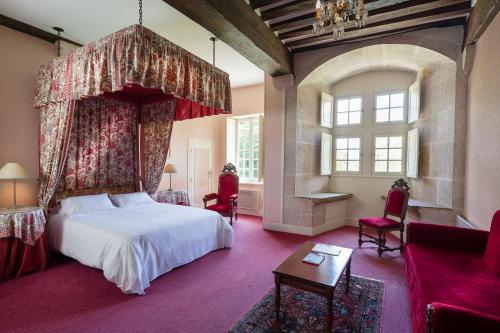 a bedroom with a large bed with a canopy at Château de Bellecroix in Chagny