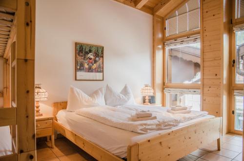 Schlafzimmer mit einem Bett mit weißer Bettwäsche und einem Fenster in der Unterkunft Apartment Stotzhalten DG - GRIWA RENT AG in Grindelwald
