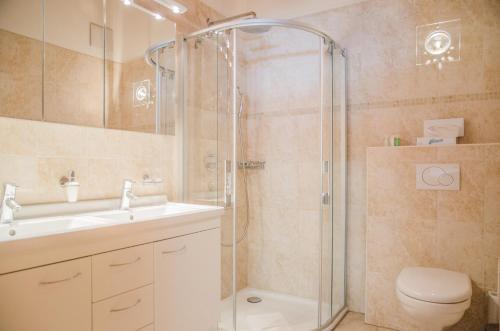 ein Bad mit einer Dusche, einem Waschbecken und einem WC in der Unterkunft Apartment Stotzhalten DG - GRIWA RENT AG in Grindelwald