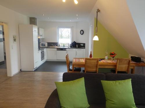 a living room and kitchen with a table and chairs at Ferienwohnung Regenbogenhaus in Hasselberg