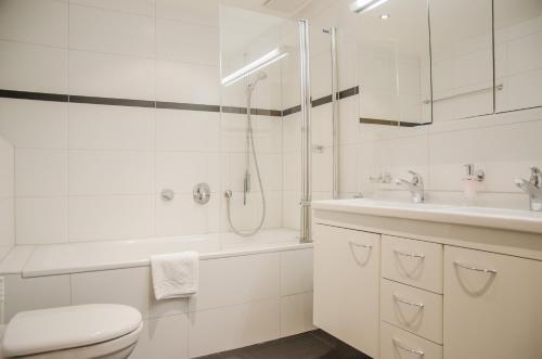 a white bathroom with a toilet and a sink at Apartment Stotzhalten 3.5 - GriwaRent AG in Grindelwald