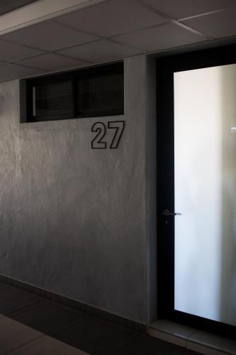 a door with the number on the wall at Apartment 27 in Windhoek
