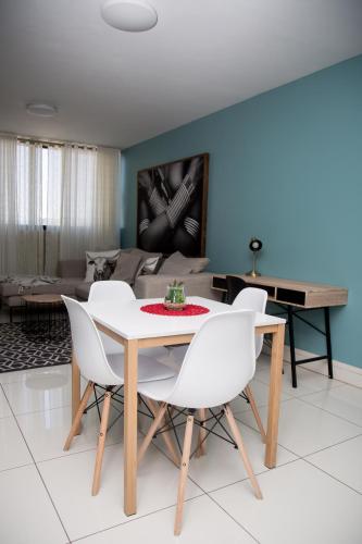 a dining room with a table and white chairs at Apartment 27 in Windhoek