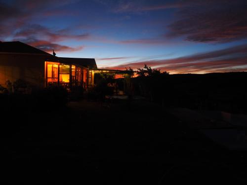 a house at sunset with the lights on at Pure Nature Familodge in Paterson