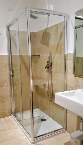 a shower with a glass door next to a sink at ZIBIBBO SUITES & ROOMS - Aparthotel in Centro Storico a Trapani in Trapani