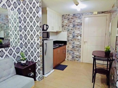 a kitchen with a couch and a refrigerator in a room at Condo Unit walking distance to Manila Airport (NAIA Terminal 3) in Manila
