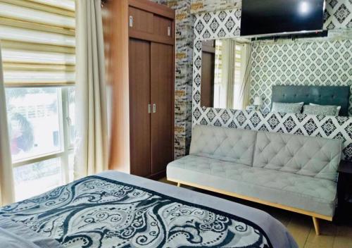 a bedroom with a bed and a couch at Condo Unit walking distance to Manila Airport (NAIA Terminal 3) in Manila