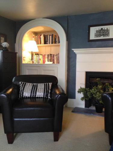 a black leather chair in a living room with a fireplace at The Brewery Tap in Abingdon