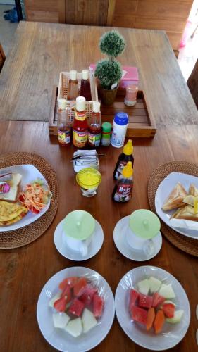 a wooden table with plates of food on it at Pujihouse One in Legian