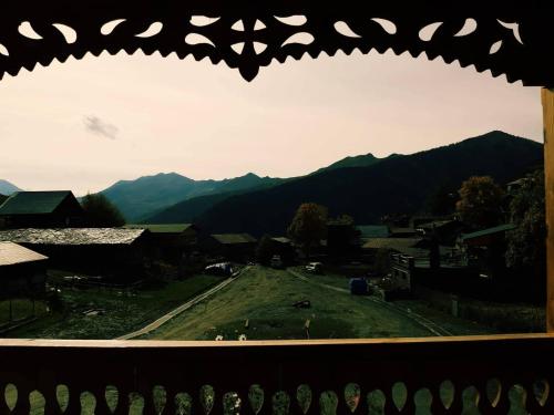 a view from a window of a field and mountains at Guesthouse Lasharai in Omalo