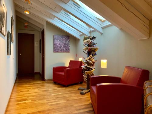 a room with two red chairs and a book shelf at Porta Ronca - B&B, Suites & Apts in Rho