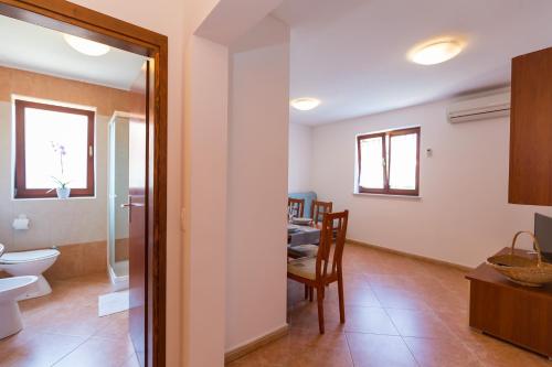a bathroom with a toilet and a dining room at Apartments Radojka in Novigrad Istria