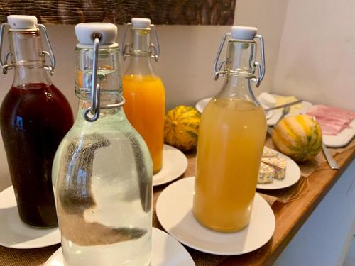 three bottles of orange juice on plates on a table at Porta Ronca - B&B, Suites & Apts in Rho