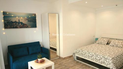プエルト・デ・ラ・クルスにあるCharming studio apartmentの小さなベッドルーム(ベッド1台、青いソファ付)