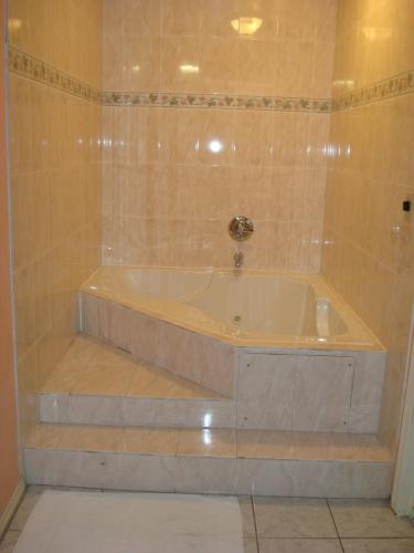 a bath tub in a tiled bathroom at Travel Inn in Los Angeles
