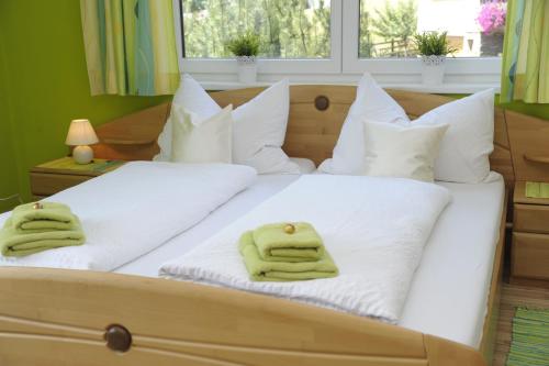 a bed with white pillows and green towels on it at Haus Sonnenschein Mariapfarr in Mariapfarr