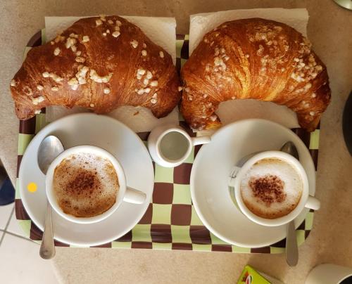 einen Tisch mit zwei Tassen Kaffee und zwei Croissants in der Unterkunft Piazza T. Galimberti - Lingotto in Turin