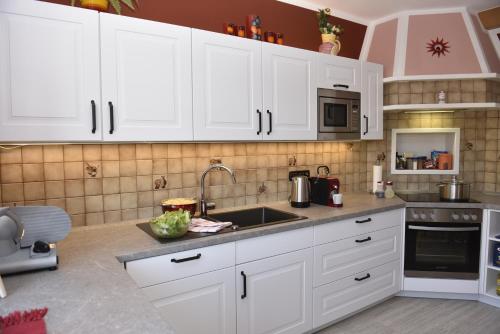 a kitchen with white cabinets and a sink at Haus Sonnenschein Mariapfarr in Mariapfarr