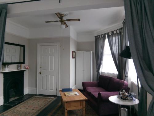 a living room with a purple couch and a fireplace at Rosslyn Court in Margate