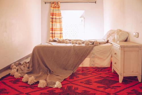 a bedroom with a bed with a blanket on it at Monkey Fingers House by Fatima mellal in Tinerhir